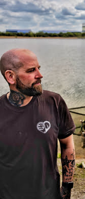 Angler wearing jag t-shirt stood next to lake